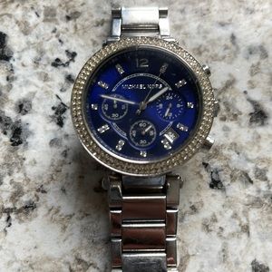 Michael Kors watch. Women’s. Blue face. Diamond trim. Silver band.